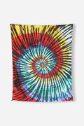 Nomadix Festival Blanket featuring vibrant tie-dye spiral design with red, yellow, green, blue, and black accents, front view.