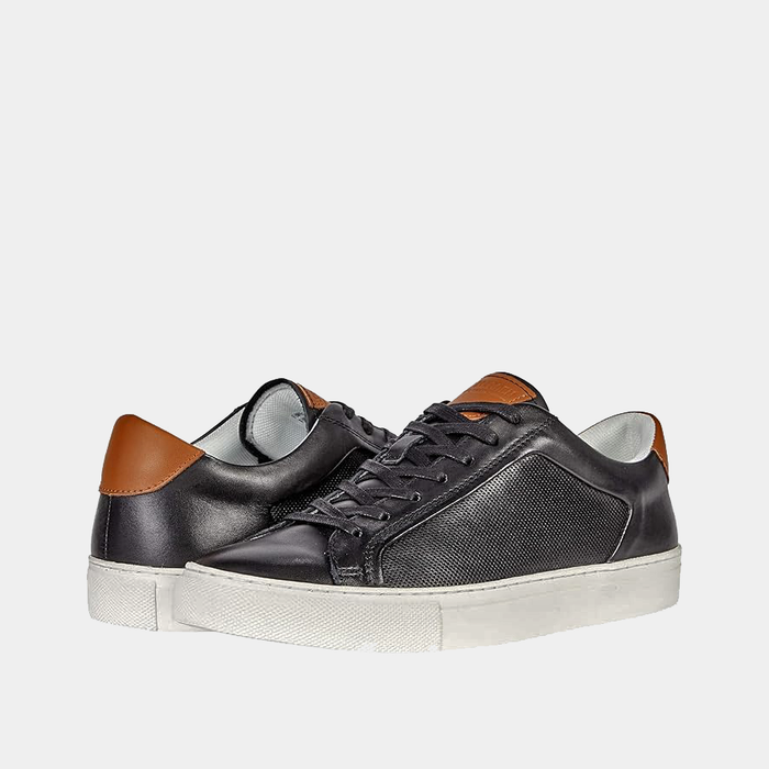 Steve Madden Finneas sneakers in black with brown accents, textured side panels, and white rubber outsole, angled front view.