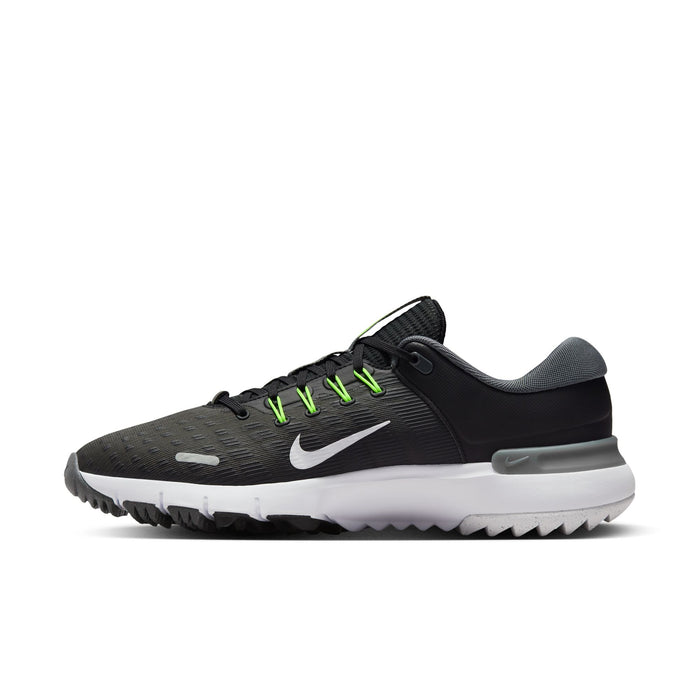 Nike Free Golf Next Nature golf shoes in black with bright green laces, white midsole, and textured outsole, side view.