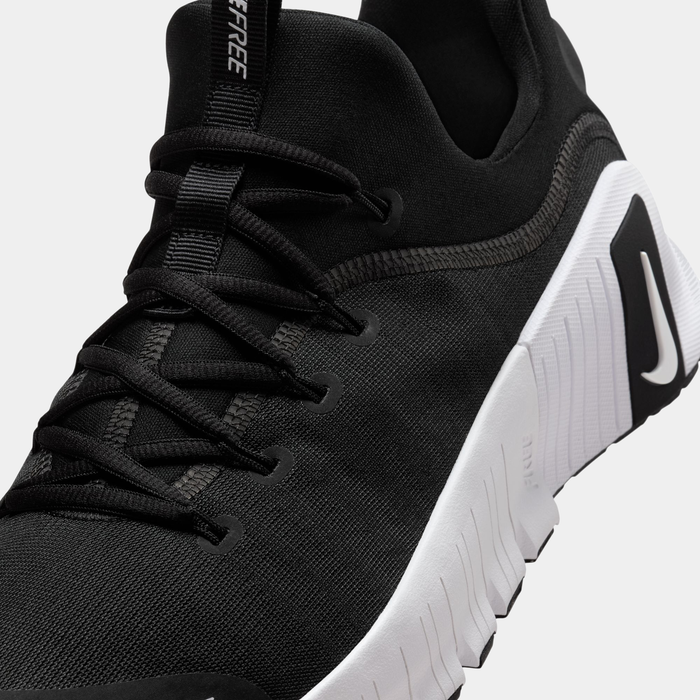 Nike Free Metcon 6 TB training shoes in black with breathable mesh upper and white midsole, angled close-up of laces and side detailing.
