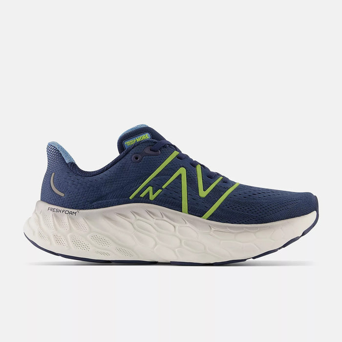New Balance Fresh Foam More v4 running shoes in navy blue with green accents, breathable mesh upper, and cushioned white midsole, side view.