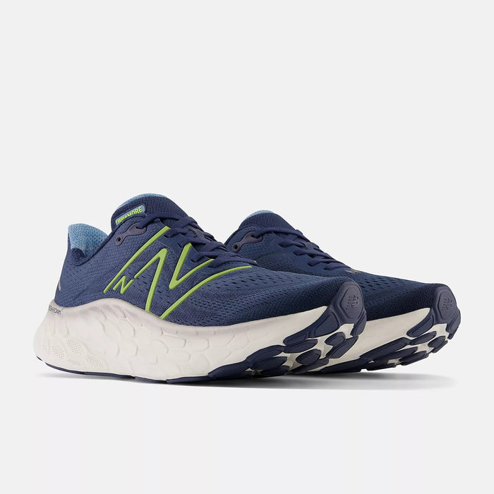 New Balance Fresh Foam More v4 running shoes in navy blue with lime green accents, featuring a cushioned white midsole and durable outsole, front angle view.