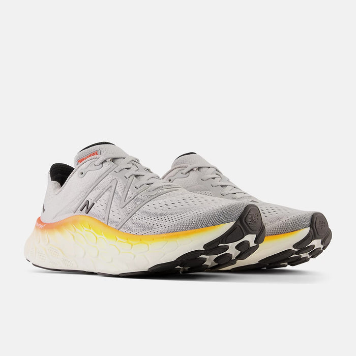 New Balance Fresh Foam More v4 running shoes in gray with mesh upper, gradient yellow midsole, and black outsole, front angled view.