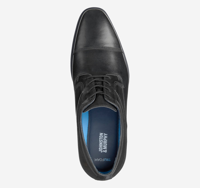 Johnston & Murphy Gibbons Cap Toe dress shoe in black leather with a cap toe design and lace-up closure, top view.