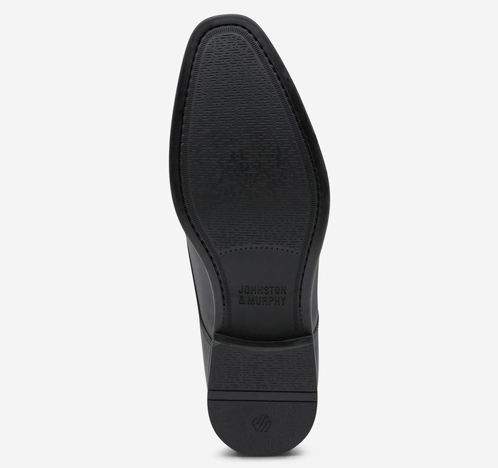 Johnston & Murphy Gibbons Cap Toe outsole in black rubber with textured grip and embossed branding, sole view.