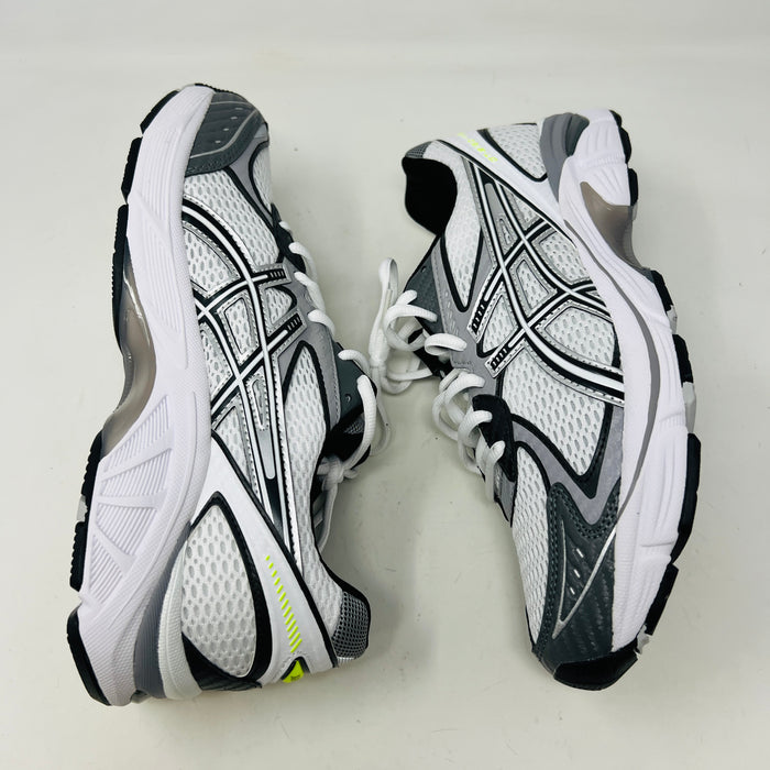 A brand new pair of ASICS GT-2160 JJJJound White sneakers, featuring mesh details and black stripes, is displayed on a black ASICS shoe box with extra laces in front for a complete authentic look.