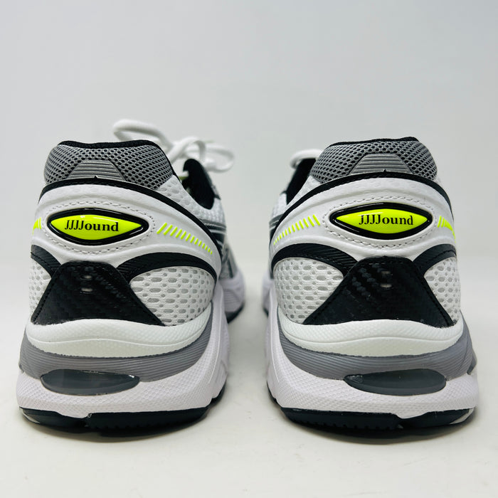 A brand new pair of ASICS GT-2160 JJJJound White sneakers, featuring mesh details and black stripes, is displayed on a black ASICS shoe box with extra laces in front for a complete authentic look.