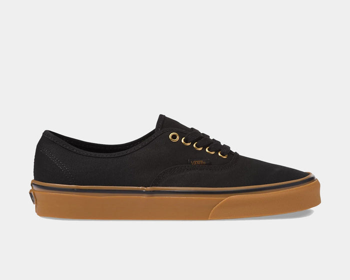 Vans Gum Authentic sneakers in black canvas with gold eyelets and gum rubber outsole, side view.