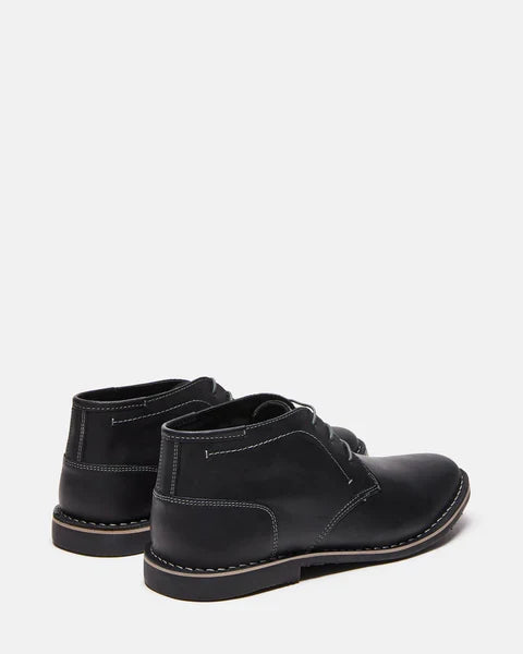 Steve Madden Harken boots in black leather with stitched detailing and sturdy soles, back angle view.