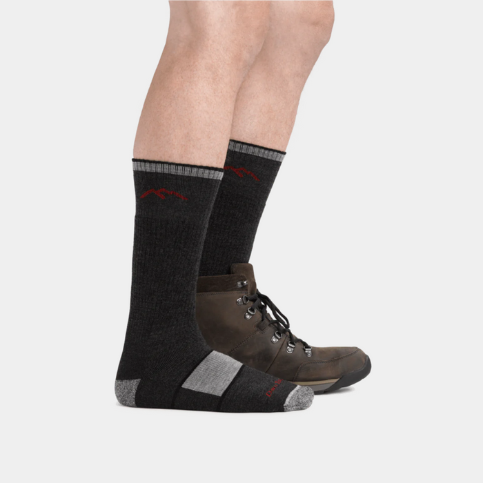 Darn Tough Hiker Boot Midweight Hiking Sock in dark gray with reinforced heel and toe, worn with brown hiking boots.