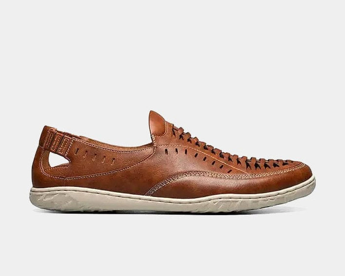 Stacy Adams Ibiza slip-on shoes in cognac brown leather with woven detailing and perforations, side view showing white rubber sole.