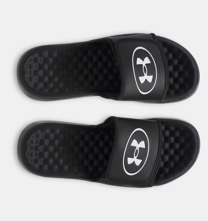 Under Armour Ignite Pro 8 slides in black with white logo, featuring textured foam footbed and adjustable strap, top view.