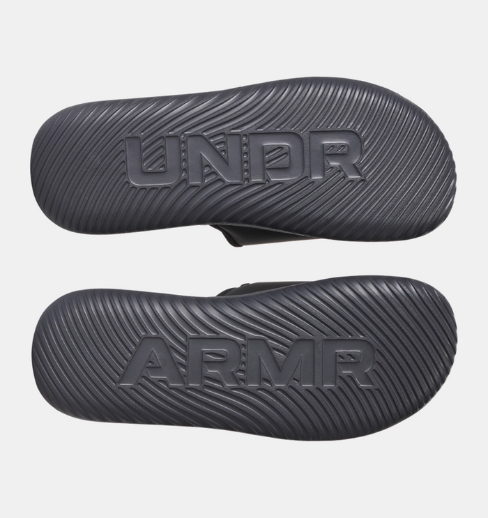 Under Armour Ignite Pro 8 Slides outsole in black with textured grip pattern and embossed branding, sole/bottom view.