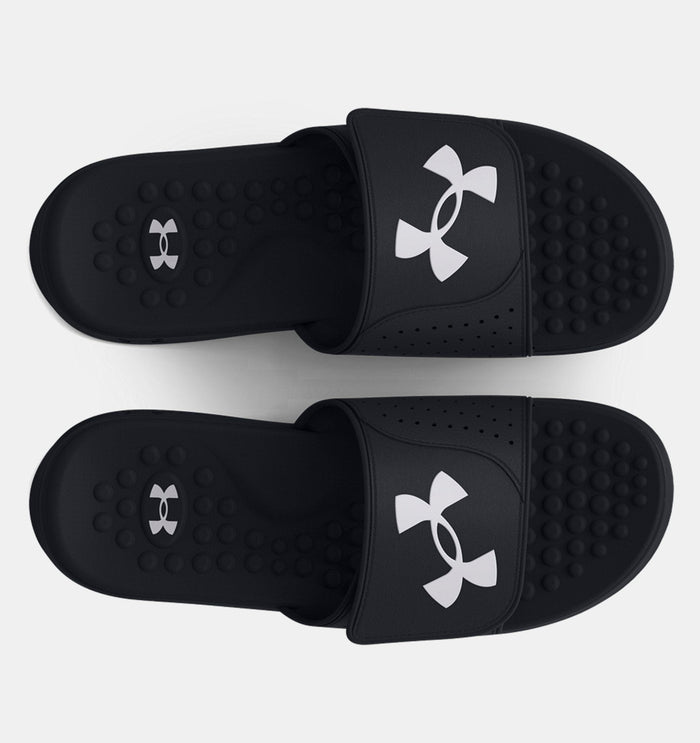 Under Armour Ignite Pro SL slides in black with white logo, cushioned footbed with textured massage nodes, top view.