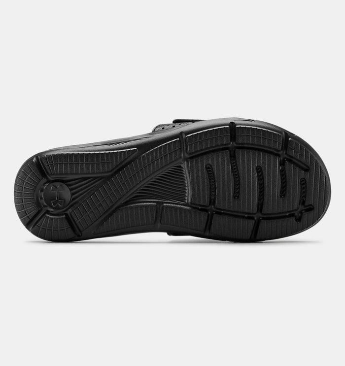 Under Armour Ignite VI SL sandals outsole in black, featuring textured tread pattern and durable rubber construction, bottom view.