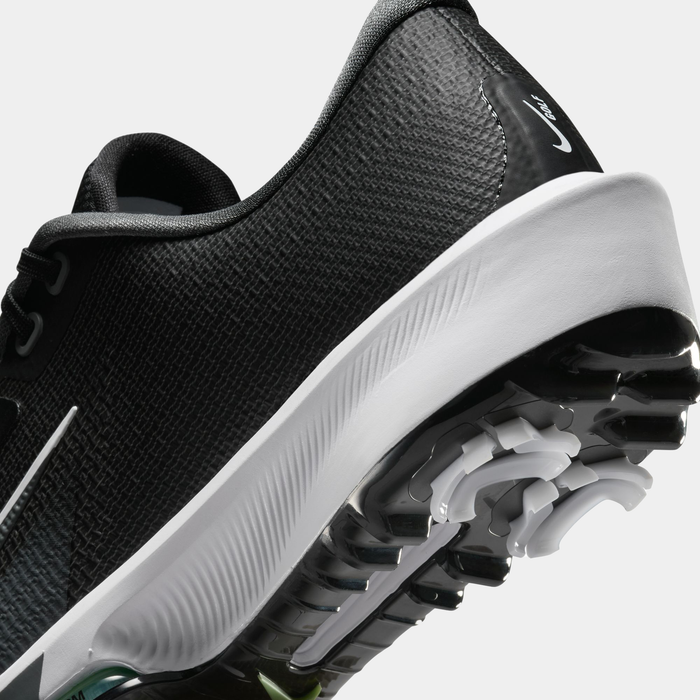 Nike Infinity Tour 2 golf shoes in black with textured upper, white midsole, and spiked outsole, angled close-up view.