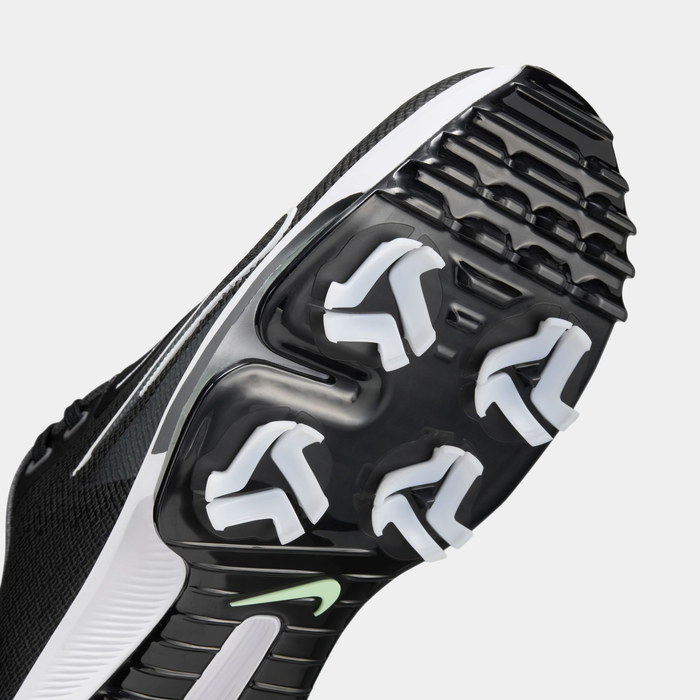 Nike Infinity Tour 2 golf shoes outsole with black and white spikes, molded grip design, and lime green logo, sole view.