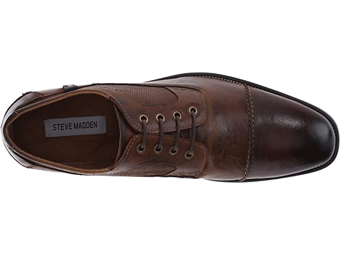 Steve Madden Jagwar dress shoe in brown leather with perforated accents, lace-up closure, and stitched cap-toe design, top view.