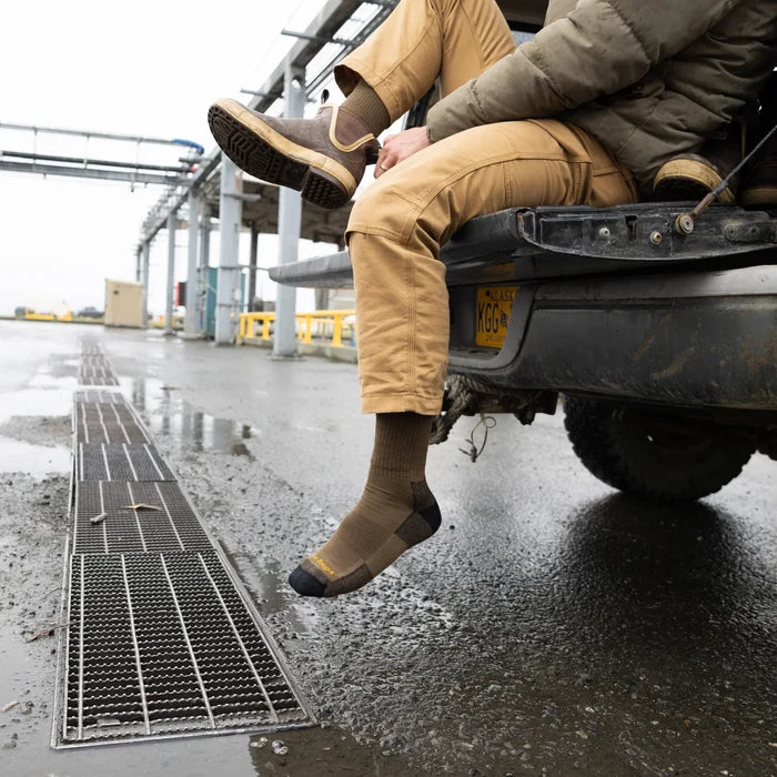 "Darn Tough John Henry Boot Midweight Work Sock in brown with reinforced toe and heel, worn outdoors on a worksite"
