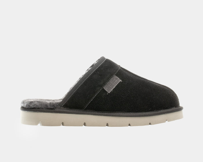 SuperLamb Khulan slippers in black suede with plush gray lining and beige treaded sole, side view.