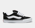 Vans Knu Skool Core sneakers in black suede with white side stripe, thick white laces, and vulcanized outsole, side view.