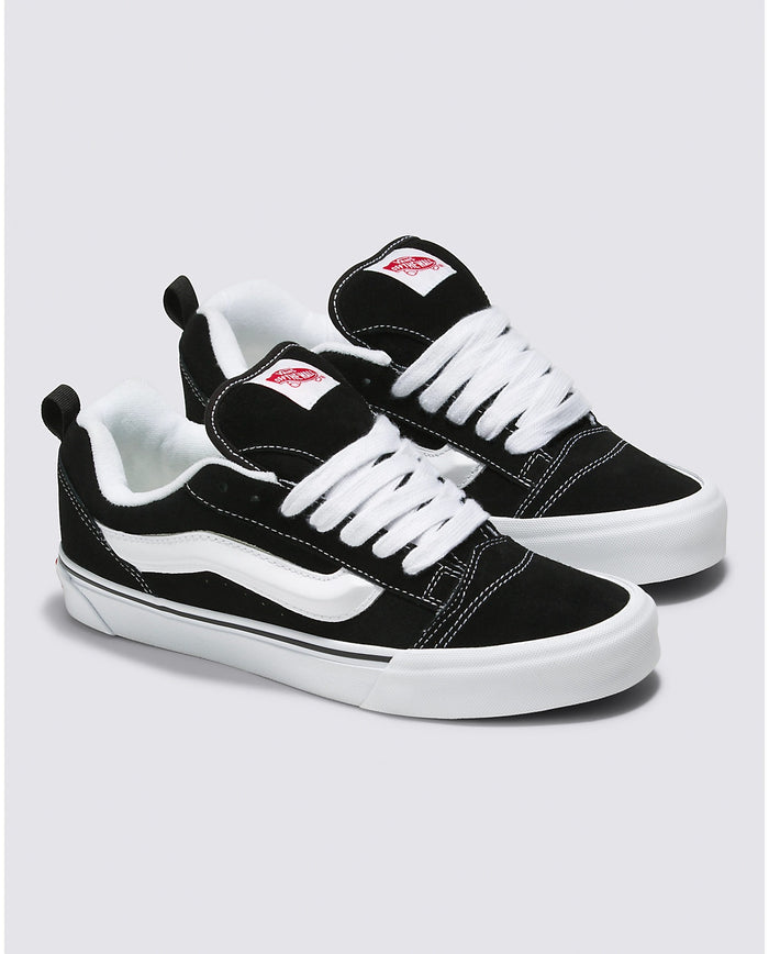 Vans Knu Skool Core sneakers in black suede with white stripe detailing, oversized laces, and padded collars, angled view.