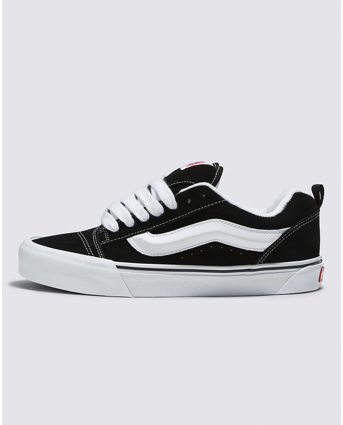 Vans Knu Skool Core sneakers in black suede with white side stripe, padded tongue, and white rubber outsole, side view.