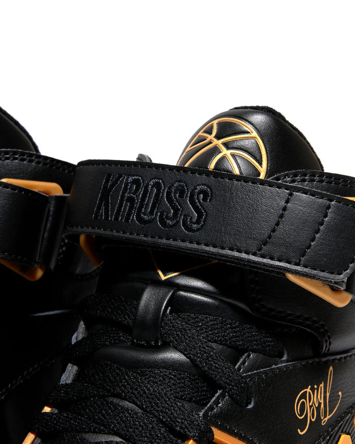 Ewing Athletics KROSS X "BIG L" sneakers in black with gold accents, bold KROSS strap detail, and signature embroidery, close-up view.