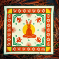 Bandits "La Magia De Tochtli" bandana featuring vibrant orange, yellow, green, and white rabbit-themed design with floral and geometric accents, flat lay view.