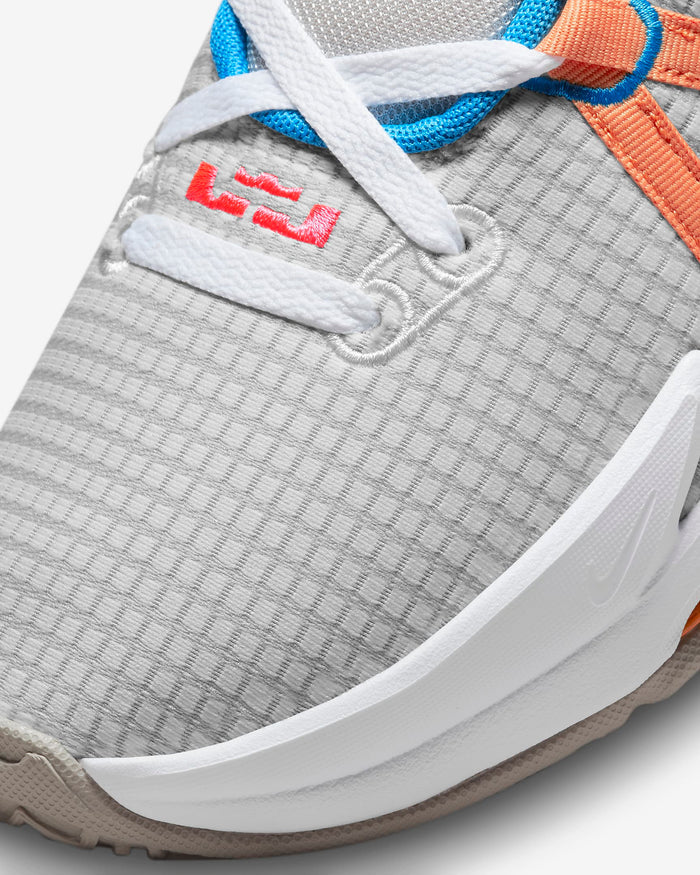 Nike LeBron Witness 7 basketball shoes, close-up of toe box and upper in gray textured mesh with white laces and orange accents.