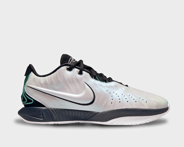 Nike Lebron XXI "Conchiolin" basketball shoes in iridescent white with black accents, large Swoosh logo, and cushioned sole, side view.
