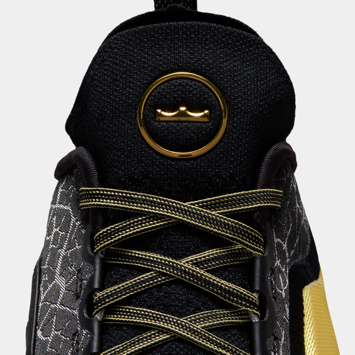 Nike LeBron XXIII Elite "Hurt Feelings" basketball shoe with black woven upper, gold eyelet detailing, and gold-accented laces, close-up front view.
