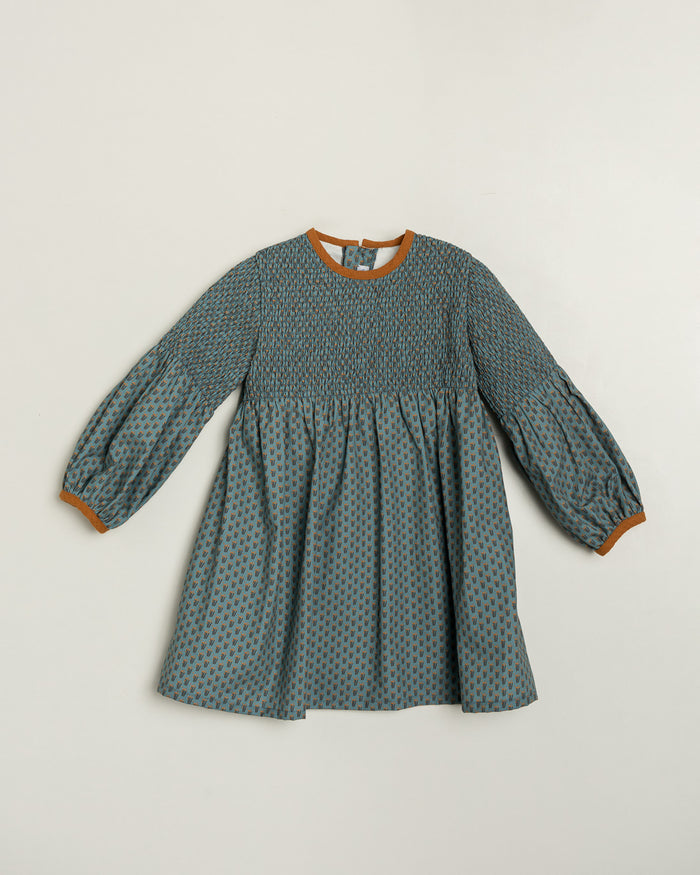 Green patterned dress with brown trim on a light gray background