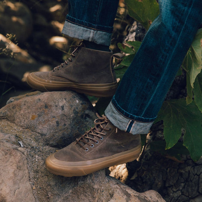 SeaVees Mammoth Boot in brown leather with gum rubber sole and lace-up design, worn outdoors on rocks.