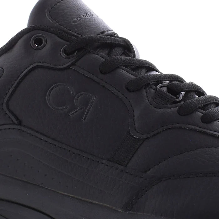 Close-up of a black sneaker with brand logo on a white background