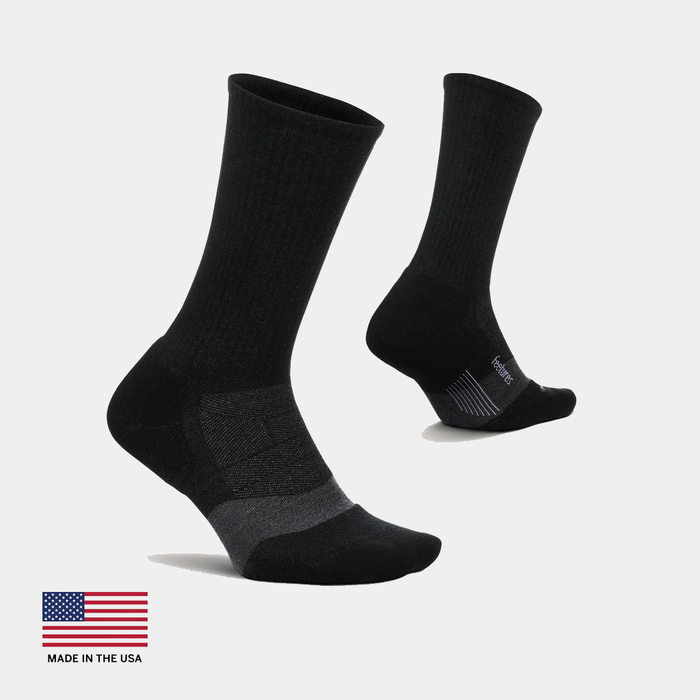 Feetures Merino 10 Ultra Light Cushion Mini Crew socks in black with reinforced heel and toe, ribbed upper, and seamless toe design, side view.
