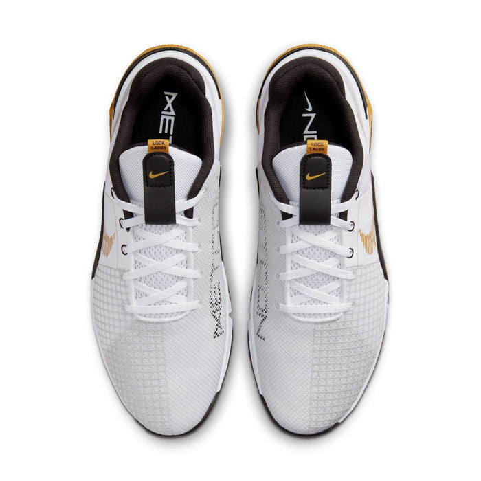 Nike Metcon 8 training shoes top view in white with mesh upper, black and gold accents, and "Lock Laces" system.