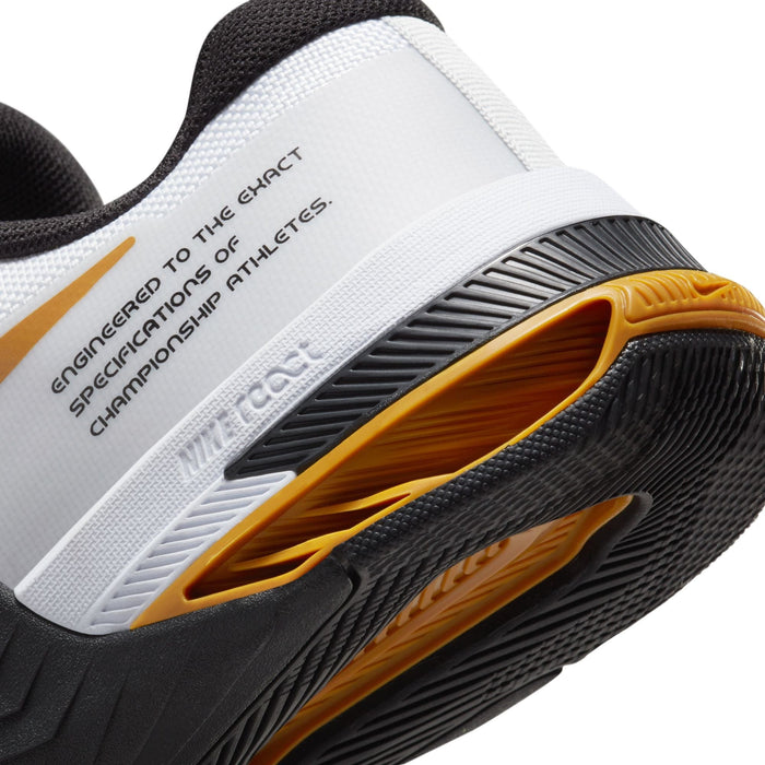 Nike Metcon 8 training shoes back view showcasing heel stability with white and black upper and yellow outsole accents.