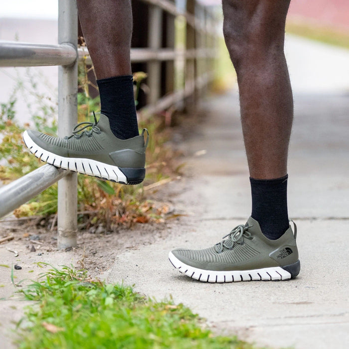Darn Tough Micro Crew Ultra-Lightweight Running Sock in black, ultra-light design with crew height, worn during outdoor activity.