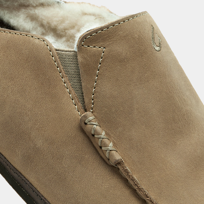 OluKai Moloa Slipper in tan suede with plush shearling lining and hand-sewn moccasin stitching, close-up side view.