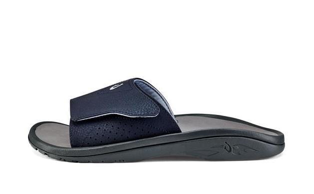 OluKai Nalu Slide sandals in navy blue with perforated strap and contoured footbed, side view.