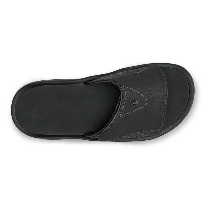 OluKai Nalu Slide sandals in black with textured leather upper and cushioned footbed, top view.