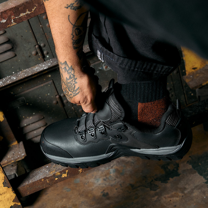 DC WorkCrew Navigator Work shoes in black with durable leather upper and rugged outsole, worn in industrial setting.