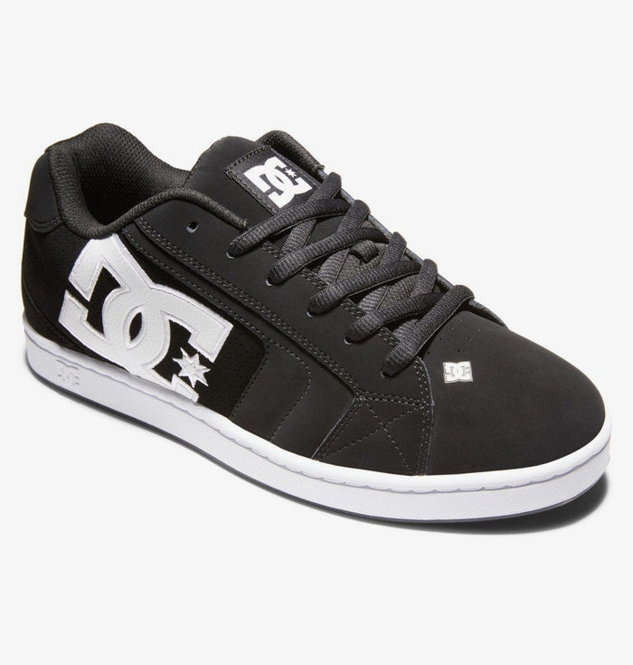 DC Footwear Net skate shoes in black with oversized white logo, padded collar, and white rubber sole, side view.