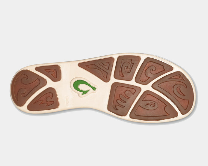 OluKai Nohea Mesh shoes outsole featuring brown rubber pods with wave-inspired patterns and a green logo detail, sole view.