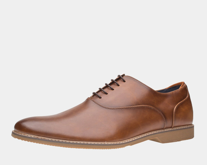 Steve Madden Nunan Plain Toe Oxford shoes in brown faux leather with a sleek design and stitched detailing, side view.