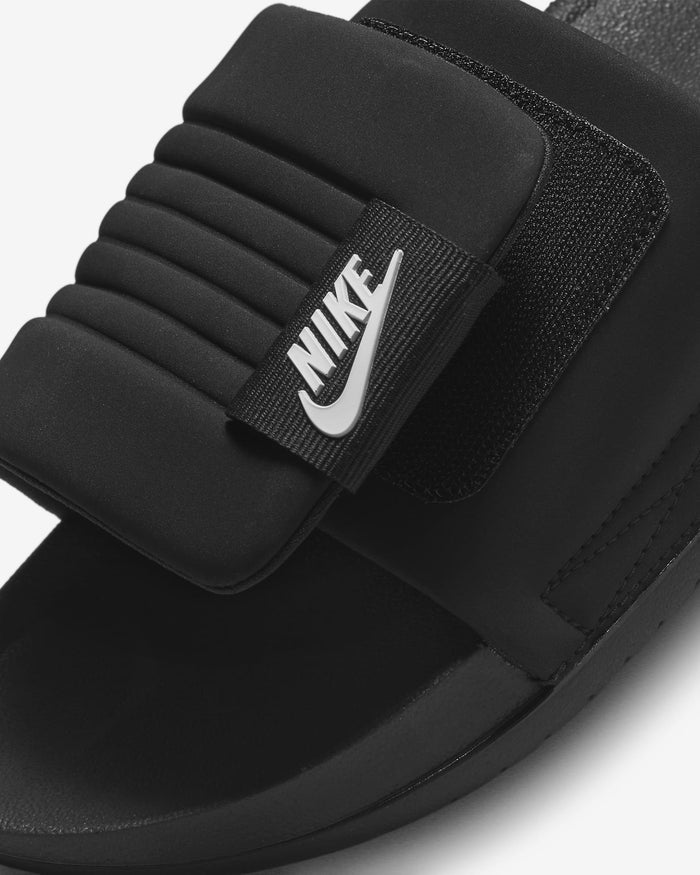Nike Offcourt Adjustable Slide sandals in black with a padded strap, Velcro closure, and embossed Nike logo, close-up view.