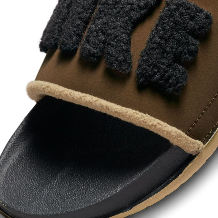 Nike Offcourt Slide SE sandals in brown with textured black logo detailing and soft fleece trim, close-up of toe area.