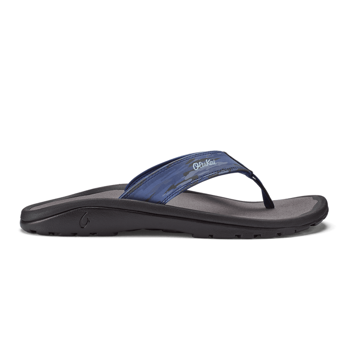 OluKai Ohana Pa'i sandals in blue camo with a black sole, featuring a water-resistant strap and anatomical footbed, side view.
