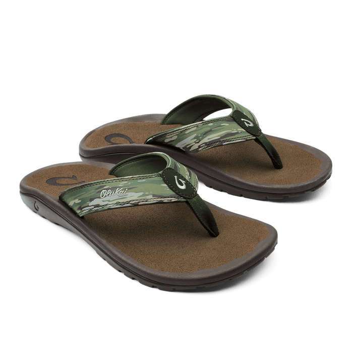 OluKai Ohana Pa'i sandals with camouflage-patterned straps, brown footbed, and black outsole, angled side view.